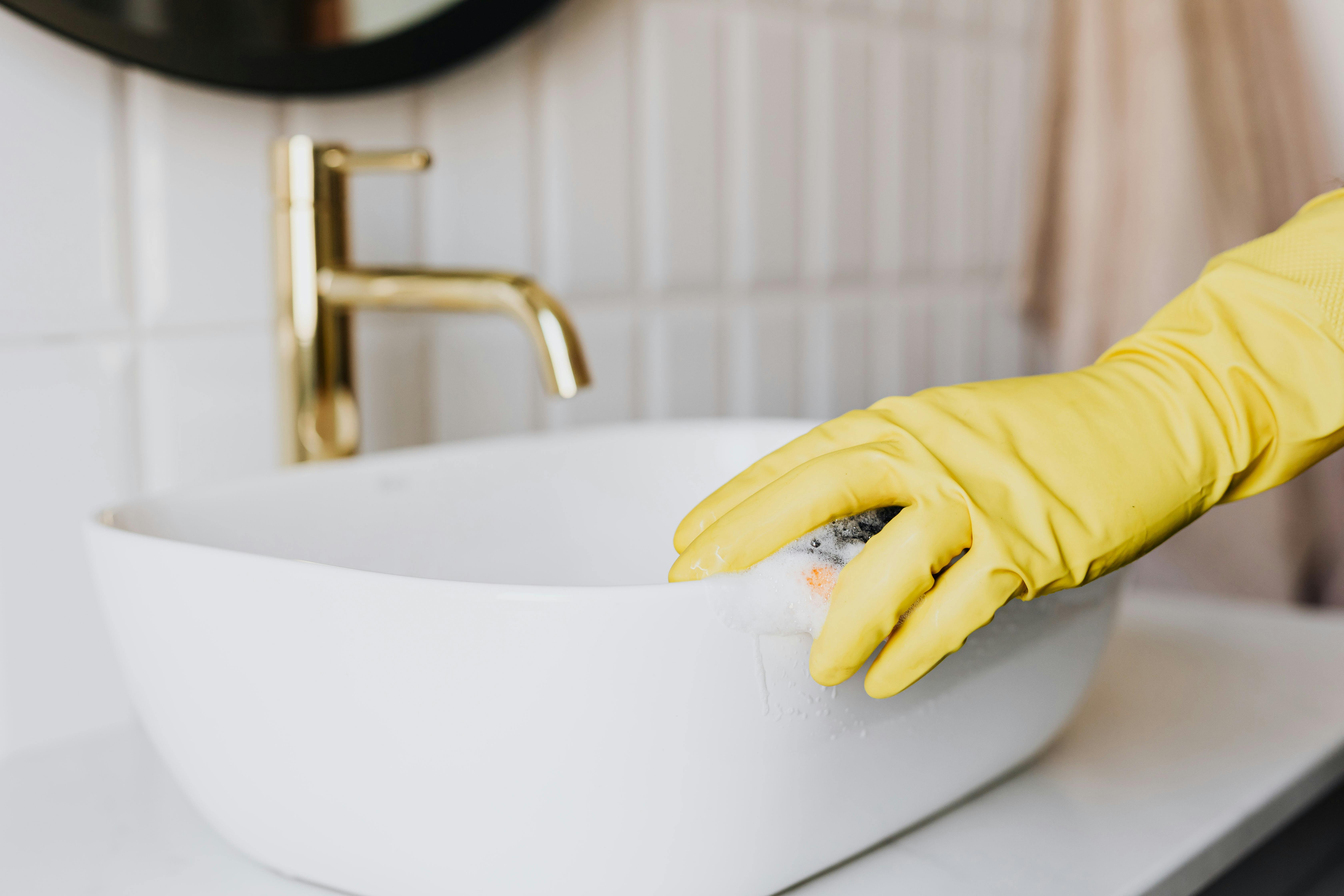 Bathroom cleaning with yellow gloves